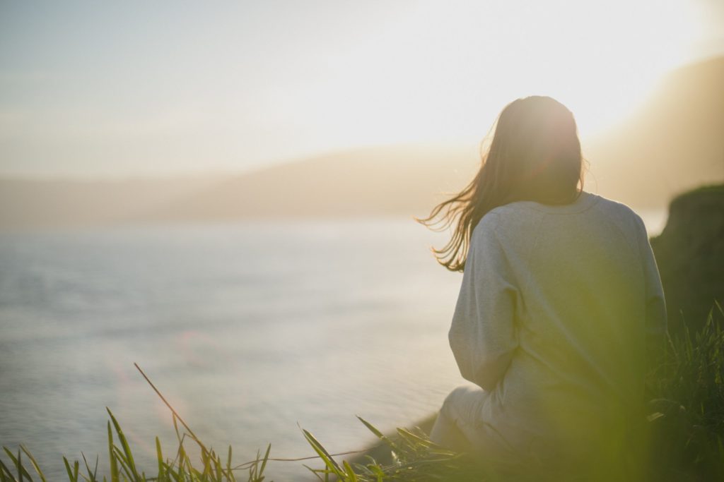An individual sitting alone, contemplating the need for supportive care, showcasing how IOP and PHP programs can provide the help they need.