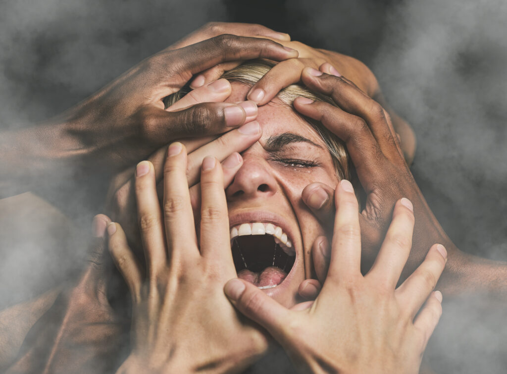 A woman with multiple hands covering her face, screaming, representing the fear of change and the overwhelming emotions tied to making a life transition.