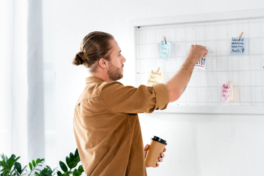 What Is an Intensive Outpatient Program? A Week Inside an IOP 1 Man adding notes to a weekly planner board, mapping out the week the way an IOP schedule is planned